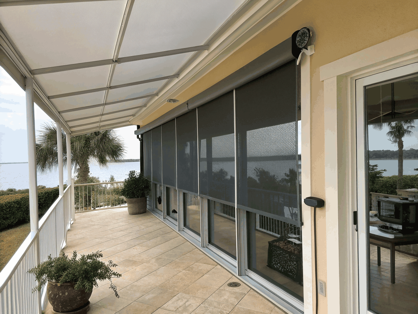 Exterior motorized zip screen system on patio facade.