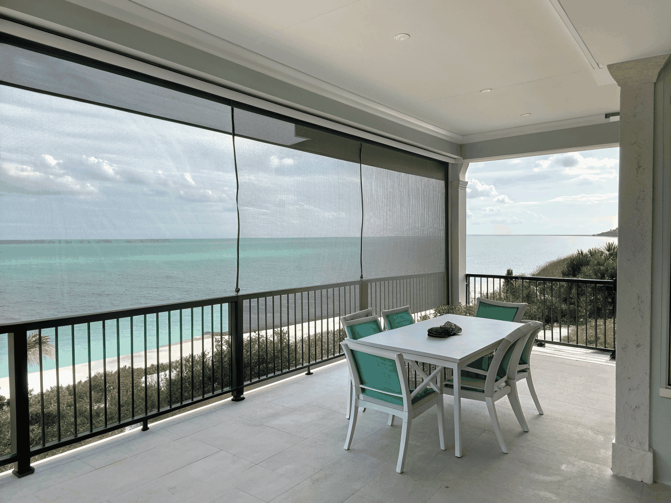 Coastal resort terrace with exterior wind-rated drop screens.